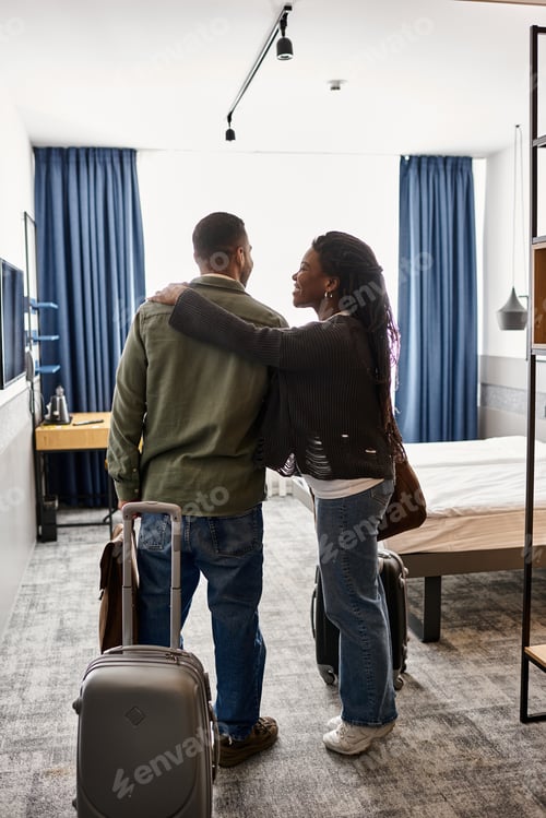 Preview: Young African American couple enjoying a romantic vacation in a cozy hotel room