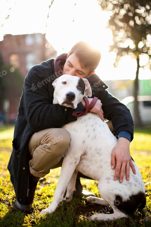 Preview: Man hugging dog in park