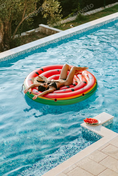 Preview: sexy woman relax in swimming pool outdoors at hot summer day