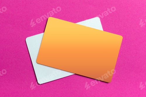 Preview: Bright orange and white cards placed on a pink background for design presentation