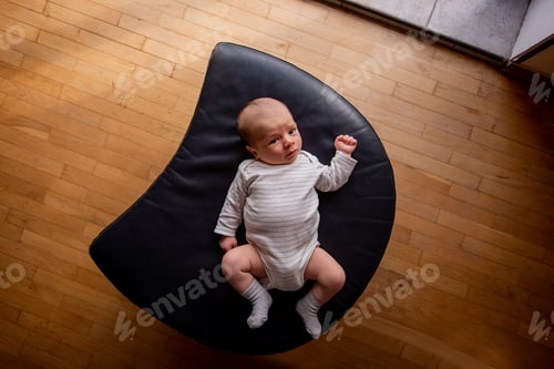 Preview: Newborn Baby Relaxing on Crescent-Shaped Cushion
