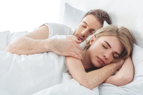 Preview: young couple sleeping in bed in bedroom