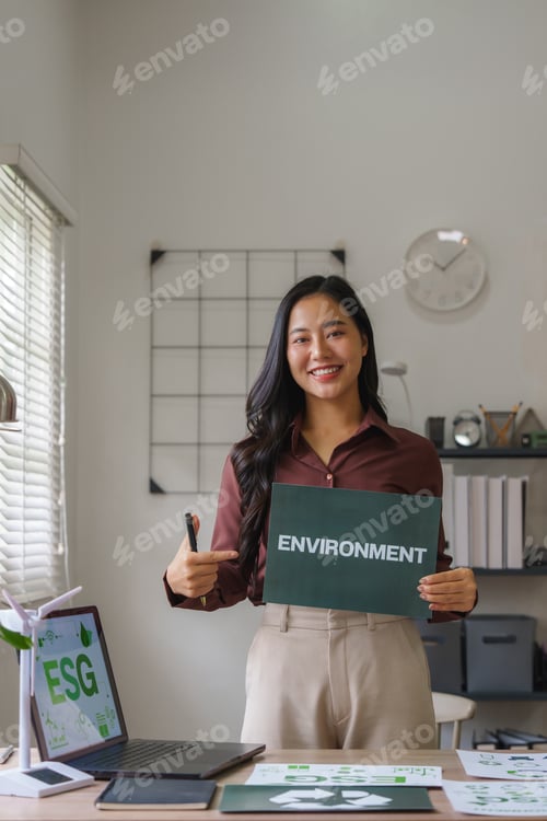 Preview: Asian businesswoman pointing at environment sign during esg meeting