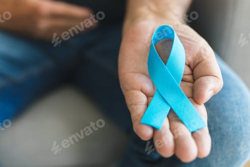 Preview: Senior man holding a blue cancer awareness ribbon