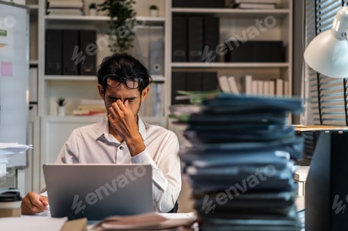 Preview: Asian businessman worker hurt eye while working on table in office.