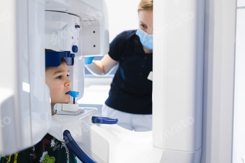Preview: Radiographer taking panoramic teeth radiography to a little boy using modern x-ray machine