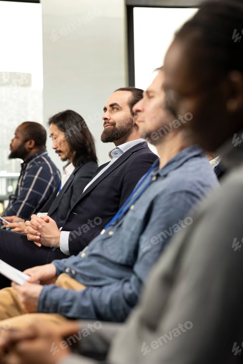 Preview: Focused male CEO in the audience paying attention to panel presentation