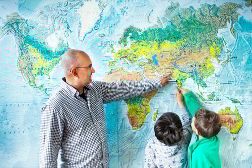 Preview: Schoolboy showing places on map to teacher in classroom