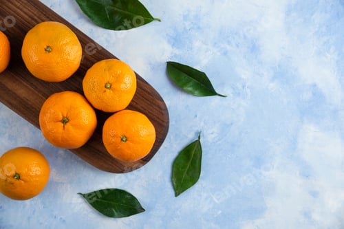 Preview: Top view of fresh juicy mandarins on wooden board