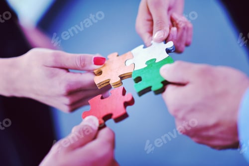 Preview: Group of business people assembling jigsaw puzzle