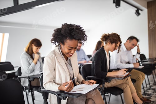 Preview: Smiling african american woman taking a test on a business seminar.