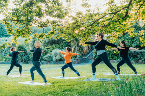 Preview: Female yoga class in park. Group of diverse women doing stretching pose exercising together
