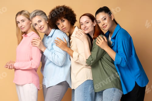 Preview: Beautiful smiling multiracial women wearing shirts isolated on beige background