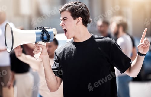Preview: We will not be silenced. Shot of a young man yelling through a megaphone during a protest.