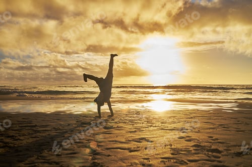 Preview: Sunset, silhouette and child doing cartwheel at the beach having fun, playing and enjoy nature. Fre
