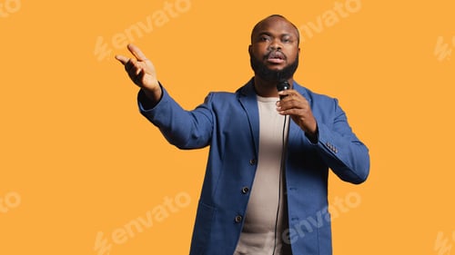 Preview: Motivational speaker holding monologue using microphone, studio background