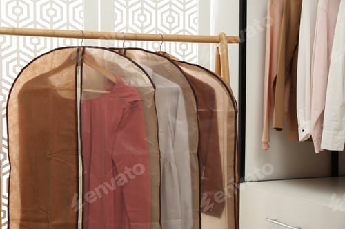 Preview: Garment bags with clothes on rack in dressing room