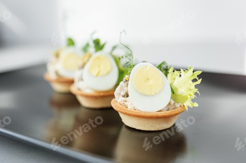 Preview: Exquisite appetizers from chef. Close-up of tartlet with quail egg and chicken and microgreens
