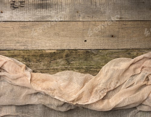 Preview: Folded gauze towel on a table made of old gray wooden boards