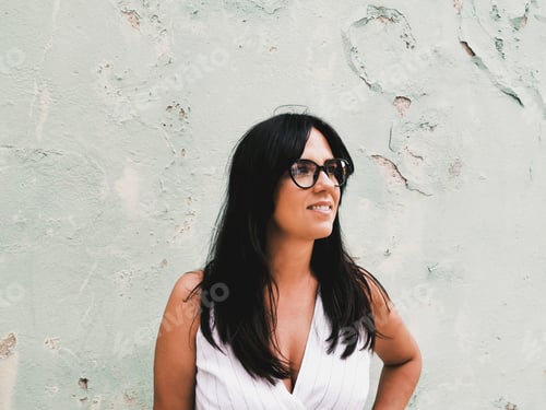 Preview: Portrait of an attractive woman with glasses in front of old wall.