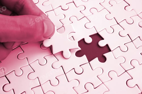 Preview: The human hand fills the last missing elements of the surface from the jigsaw puzzle