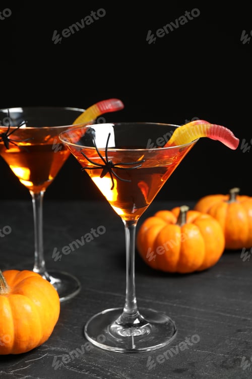Preview: Decorated glasses with drinks on grey table. Halloween celebration
