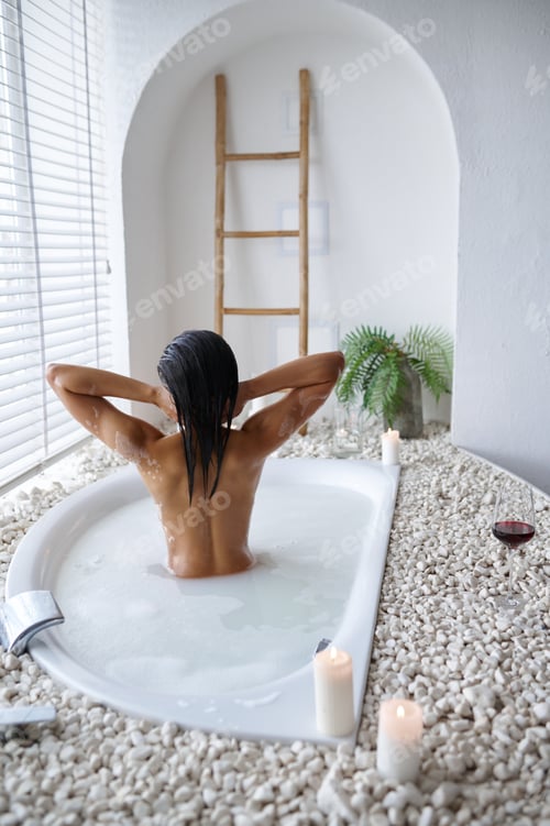Preview: Attractive woman relax in a bubble bath, back view