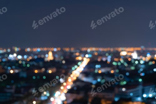 Preview: Bokeh of skyscraper buildings in city with lights, Blurry photo at night time. Cityscape background