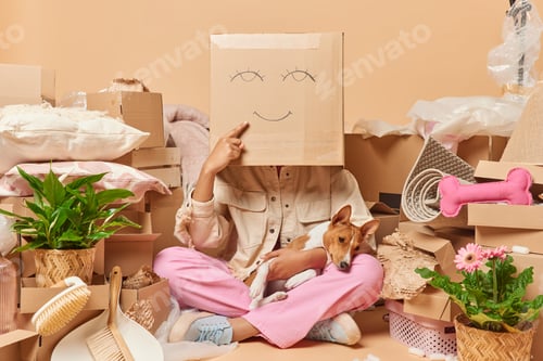Preview: Faceless woman hides behind carton box foolishes around poses on floor with dog going to live sepera