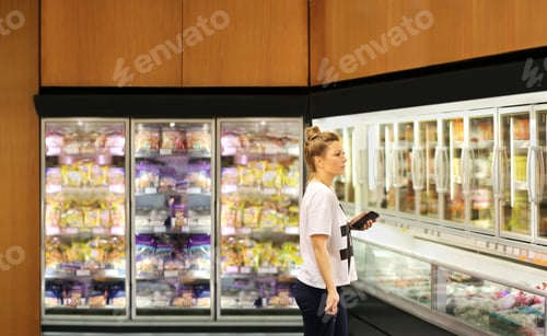 Preview: Woman Choosing Frozen Food From A Supermarket Freezer
