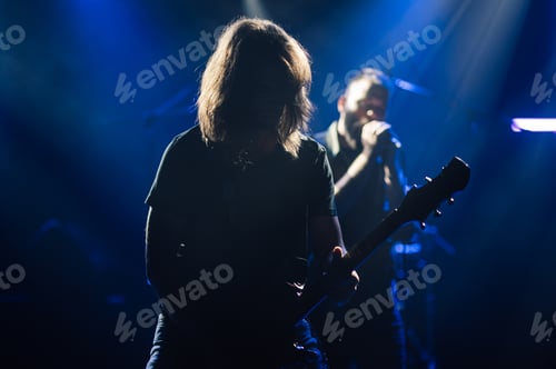 Preview: Guitarist performing on stage with singer in background