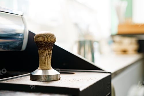 Preview: Coffee press tamper of professional coffee machine on counter