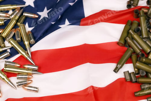 Preview: Many yellow 9mm and 5.56mm bullets and cartridges on United States flag