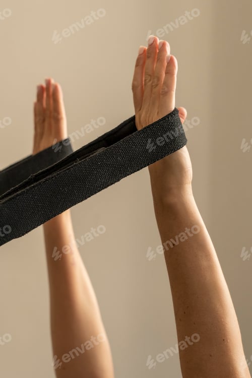 Preview: Close up of a woman's hands holding a yoga strap for an assisted stretching exercise.