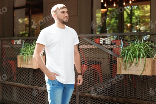 Preview: Young man wearing white t-shirt on street