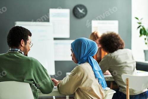 Preview: Back view of two young intercultural students discussing new subject