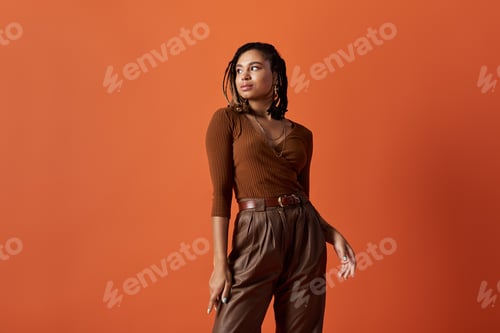 Preview: Chic young African American woman poses confidently in a vibrant studio