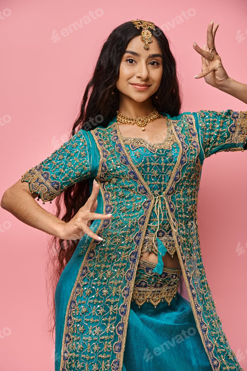 Preview: vertical shot of beautiful indian woman in national costume with accessories on pink backdrop