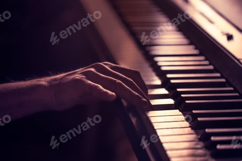 Preview: male hands on the piano keys closeup of a beautiful colorful background
