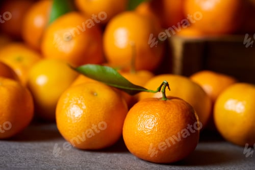 Preview: selective focus of sweet orange clementine near tangerines with green leaves