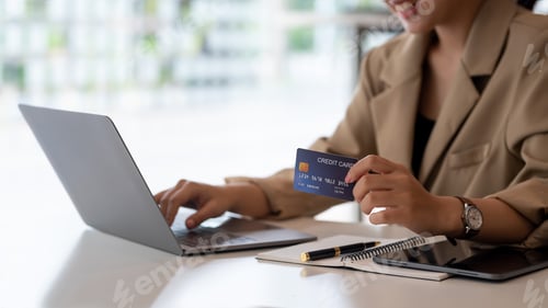 Preview: Businesswoman hand holding credit card and using laptop. Close up of female hands credit card paymen