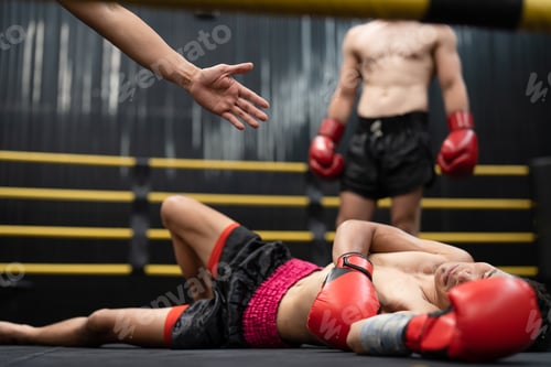 Preview: Asian boxer athlete man knocked out unconscious and lying down on floor center stage ring