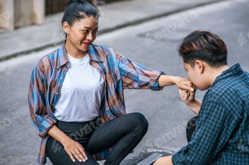 Preview: The woman of two lovers sat and kissed the hand of one another.