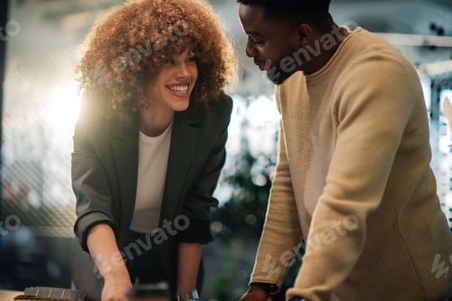 Preview: Smiling diverse colleagues discussing renewable energy technology.