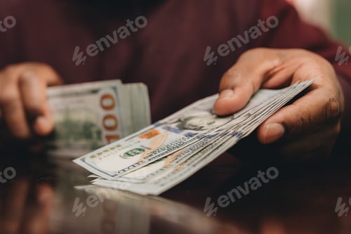 Preview: African American man offering up a pile of one hundred dollar bills
