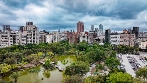 Visualização: Vista aérea do horizonte de Taipei com parque exuberante e fonte de água sob nuvens dramáticas