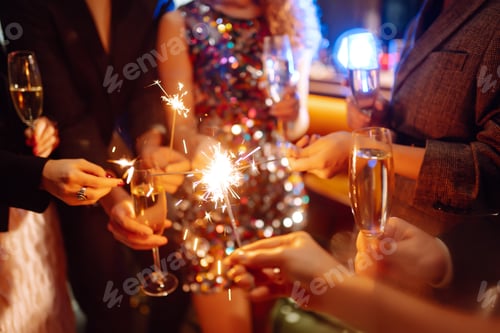 Preview: Sparkling sparklers in hands. Playing firework to celebrate winter holidays with friends at party.