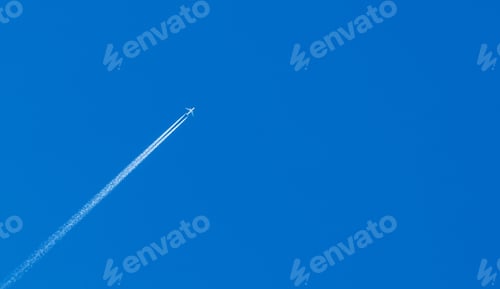 Preview: Airplane with a contrail in a blue sky