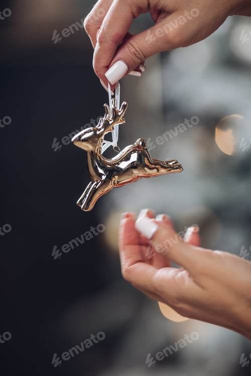 Preview: Woman hand is holding Christmas tree decoration