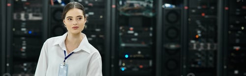 Preview: A skilled woman in a white shirt manages server systems in a high-tech data center, banner